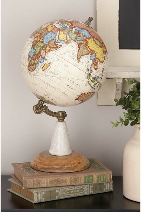 The Wood Metal Marble Globe perched on two vintage books