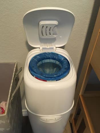 Diaper Genie with open lid showing blue bags inside