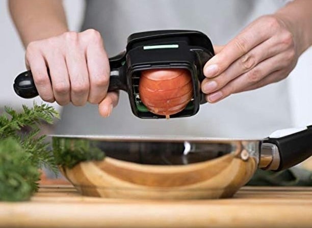 Hands slicing an onion with the food chopper