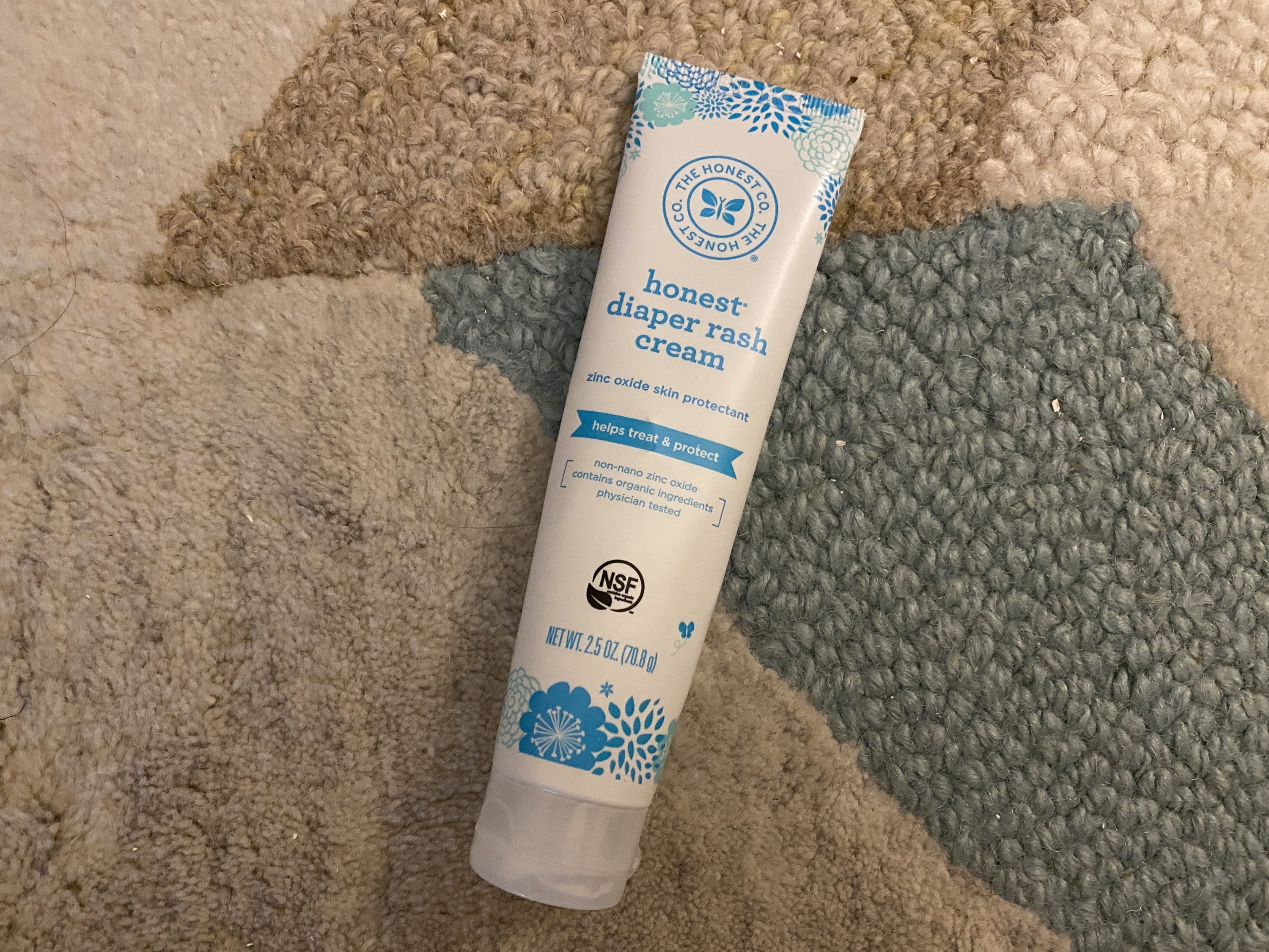 A white tube of diaper rash cream with blue lettering and logo
