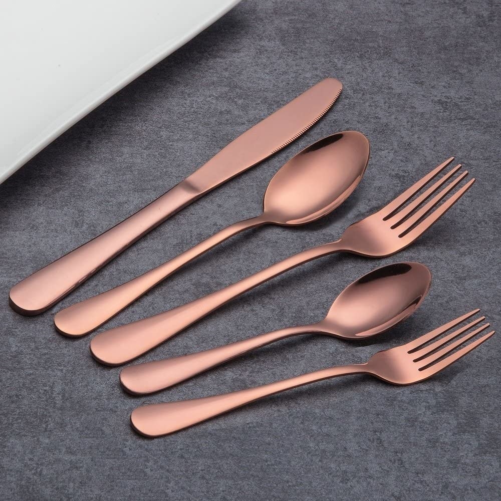 A knife, big spoon, little spoon, big fork and small fork lie flat on a table