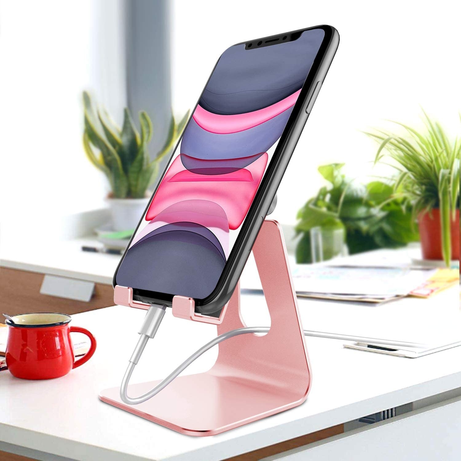 A phone stand on a desk with a phone in it that&#x27;s charging