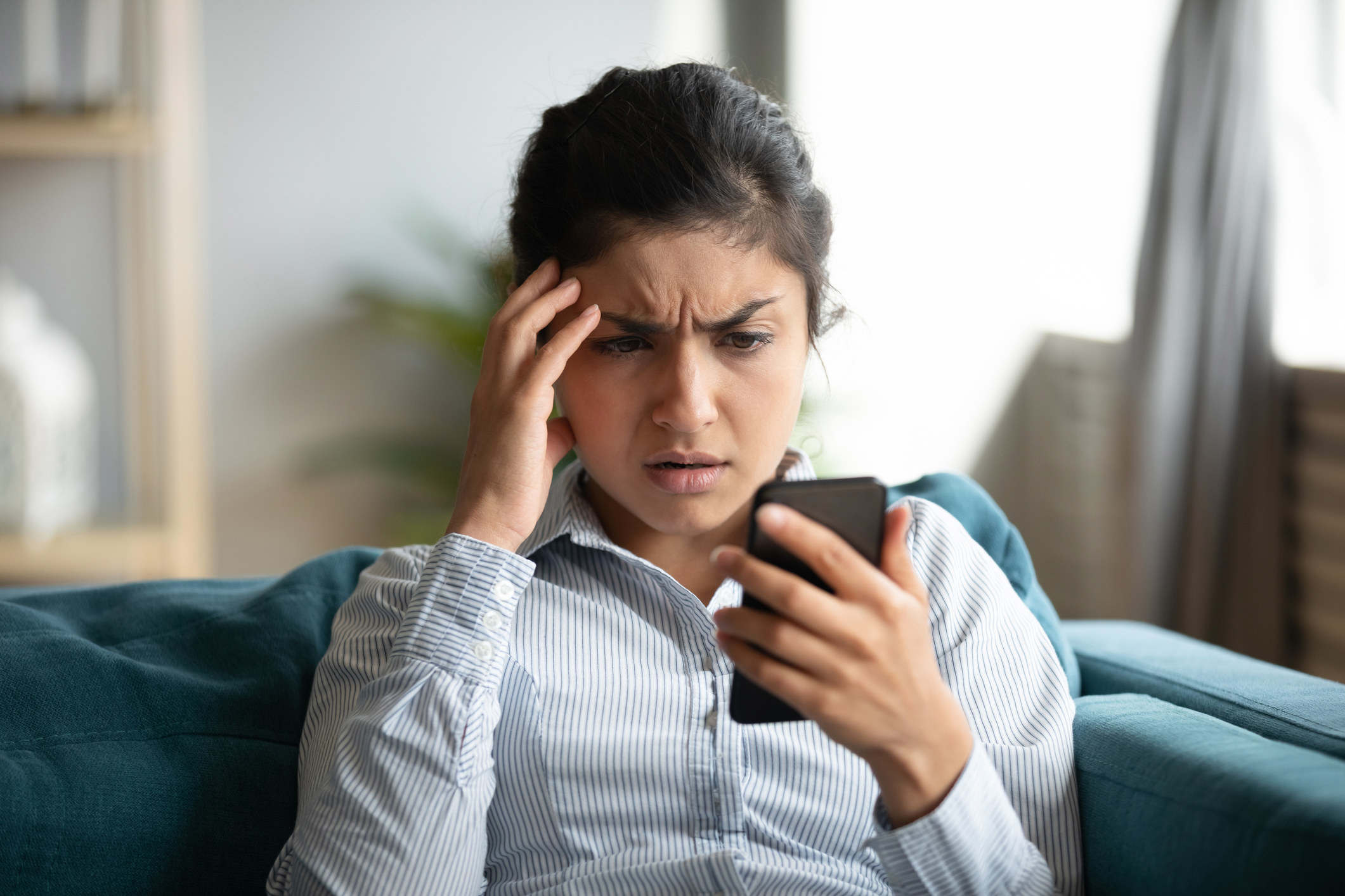 photo of a woman reading her phone in disgust