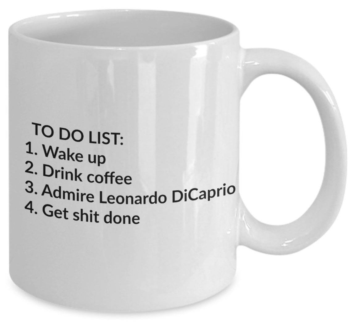 A white ceramic mug that reads, &quot;TO DO LIST: 1. Wake up 2. Drink coffee 3. Admire Leonardo DiCaprio 4. Get shit done.&quot;