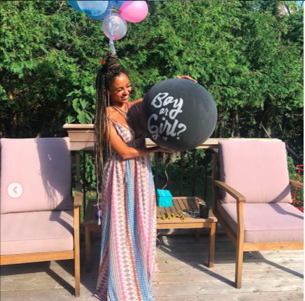 Vanessa holding a balloon that says boy or girl