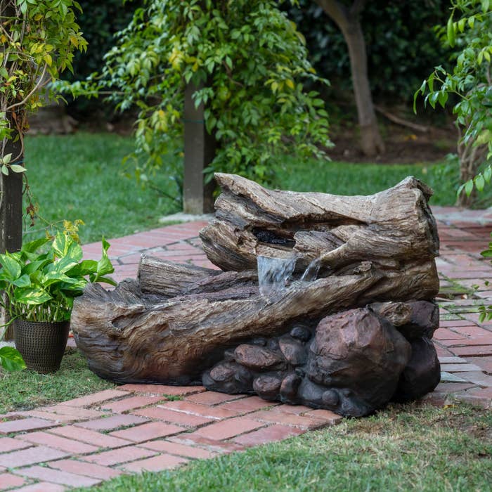 the fountain, designed to look like two logs and some stones