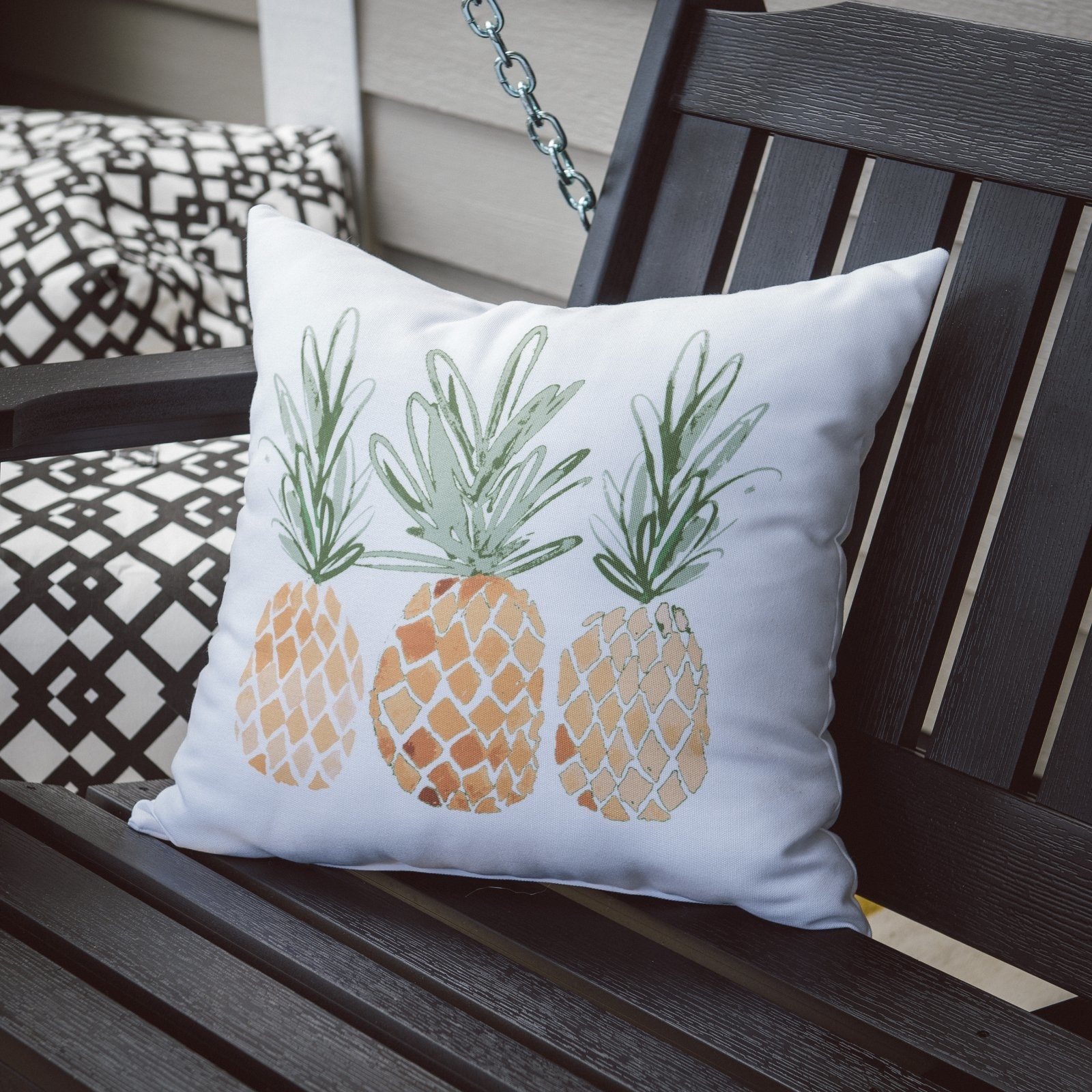 a white pillow with three pineapples on it