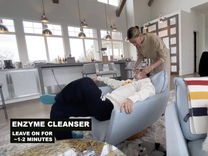 Hailey applies an enzyme cleanser onto Justin&#x27;s cheeks