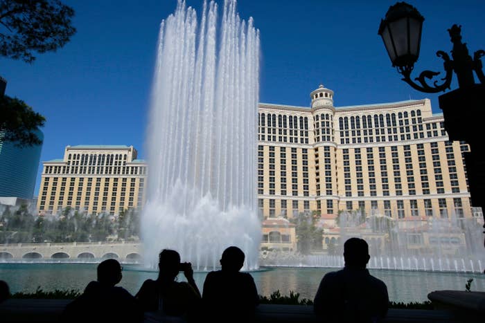 Dozens of fountains shoot jets of water high into the air as onlookers watch on in front of the multi-story Bellagio hotel.