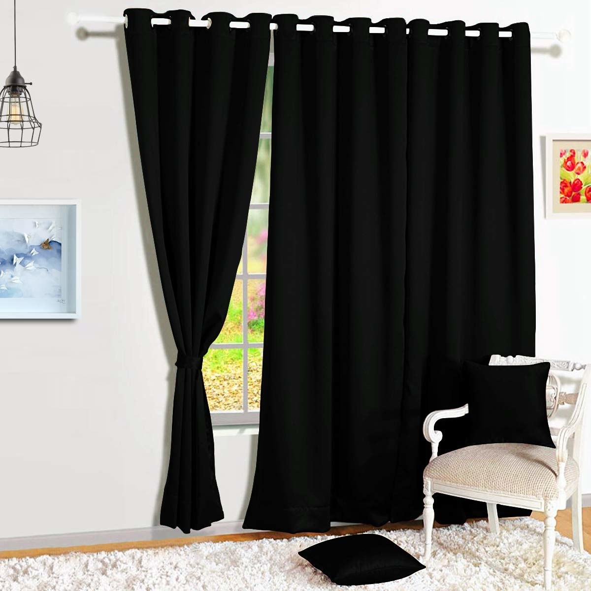 Blackout curtains on a window next to a chair with pillows on it