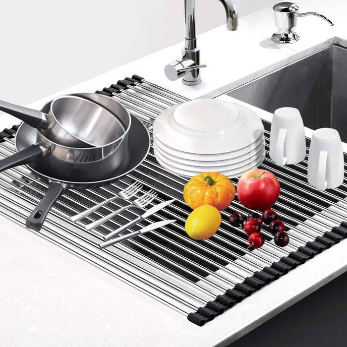 Metal drying rack that covers the sink, allowing dishes to drip dry and the water runs down the drain. 