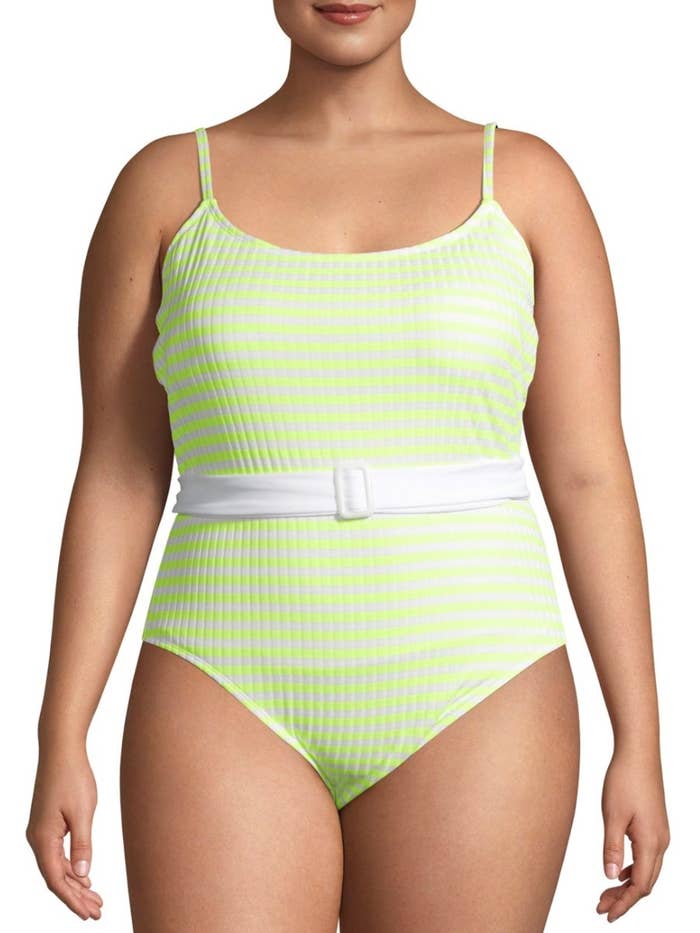 A model in a strappy neon green one piece suit
