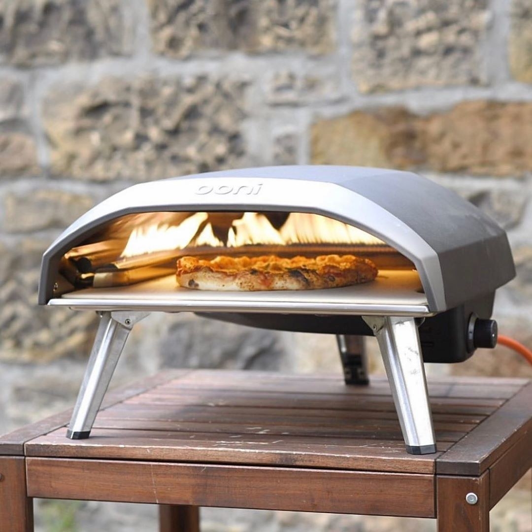 A pizza cooking inside the Ooni portable outdoor pizza oven.