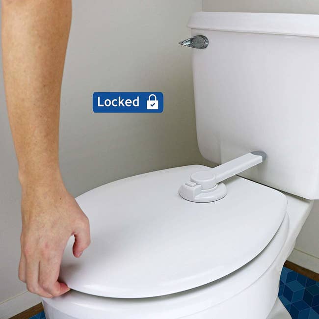 A person unable to lift the toilet seat with the toilet attachment in the locked position. The attachment is placed on the back of the closed toilet seat and connects with the toilet tank with a push-button and twist unlocking system