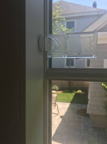 A window with the clear lock placed onto the side molding to prevent the window from opening all the way