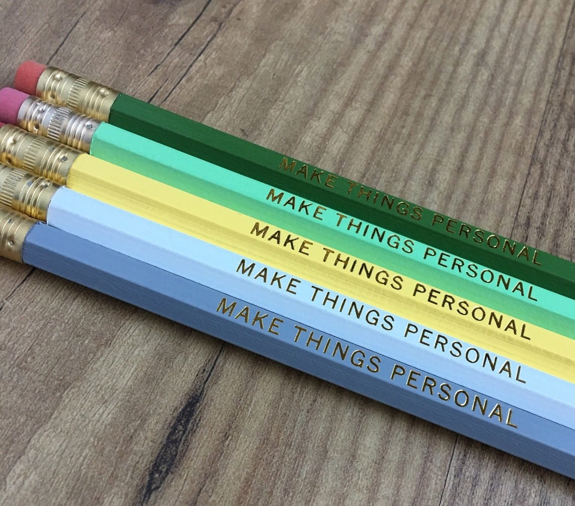 Five pencils arranged neatly on a desk with the inscription visible