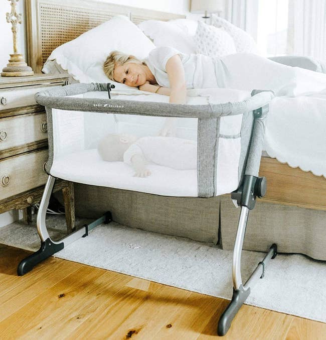 A small bassinet with an open side by the parent's bed, allowing them to reach for their baby 