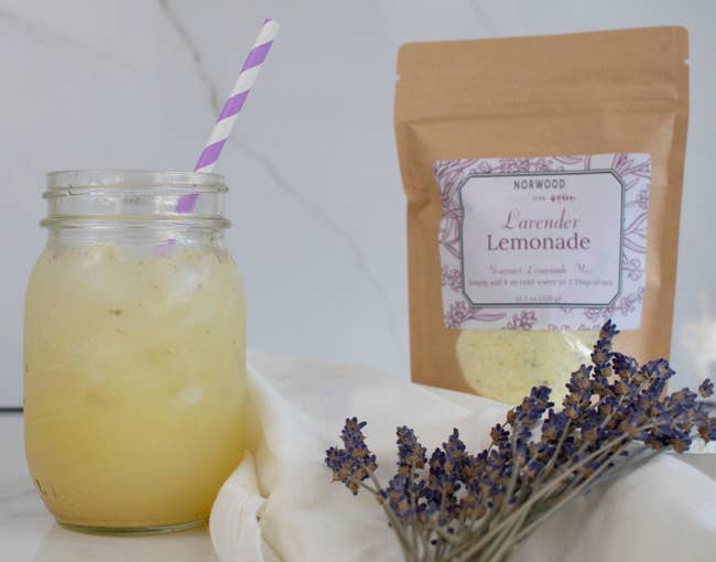 A packet of lavender lemonade with a glass of it already mixed in