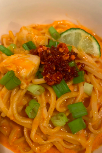 A reviewer photo of a noodle dish topped with the condiment, which has a salsa or jam-like consistency