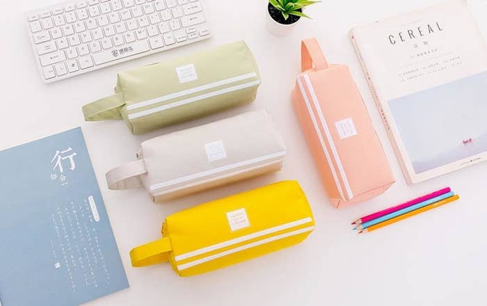 A flatlay of four pencil cases arranged neatly on a desk with other school supplies