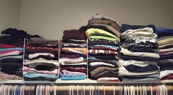 A reviewer photo of the shelves neatly separating and organizing clothes on a closet shelf