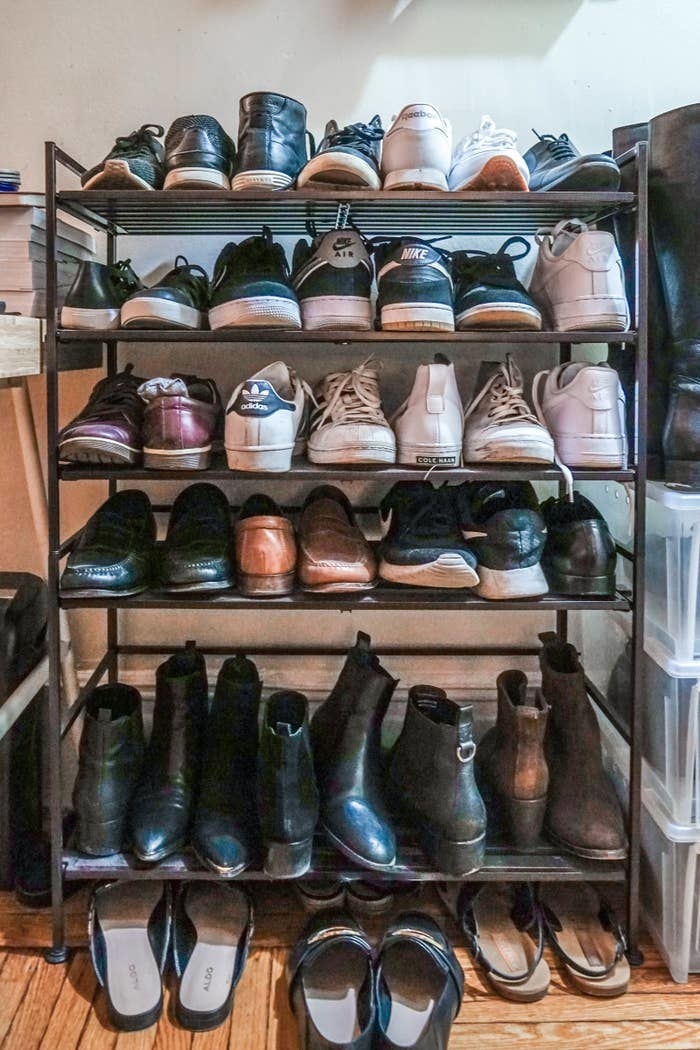 BuzzFeed Editor Yi Yang&#x27;s shoe rack with five tiers holding various shoes like boots and sneakers, with some space underneath for smaller shoes like sandals