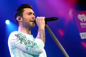 Adam Levine with hair singing into microphone