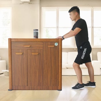 A model using furniture sliders to move a large wooden cabinet