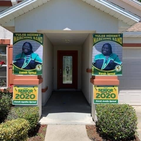 Photo of the front of Sproul home, which shows the two posters of Xanah and Xarah in their marching band uniforms.