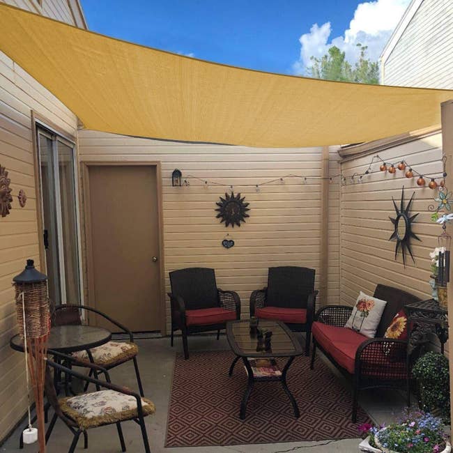 A beige canopy shade over a small outdoor porch 