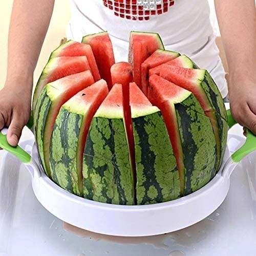A person slicing a watermelon using the slicer