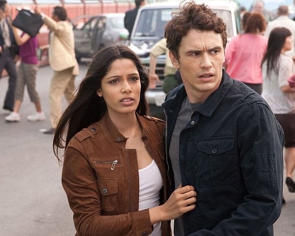 Freida Pinto as Caroline holds onto Will (James Franco) as to two look into the distance with worried expressions.