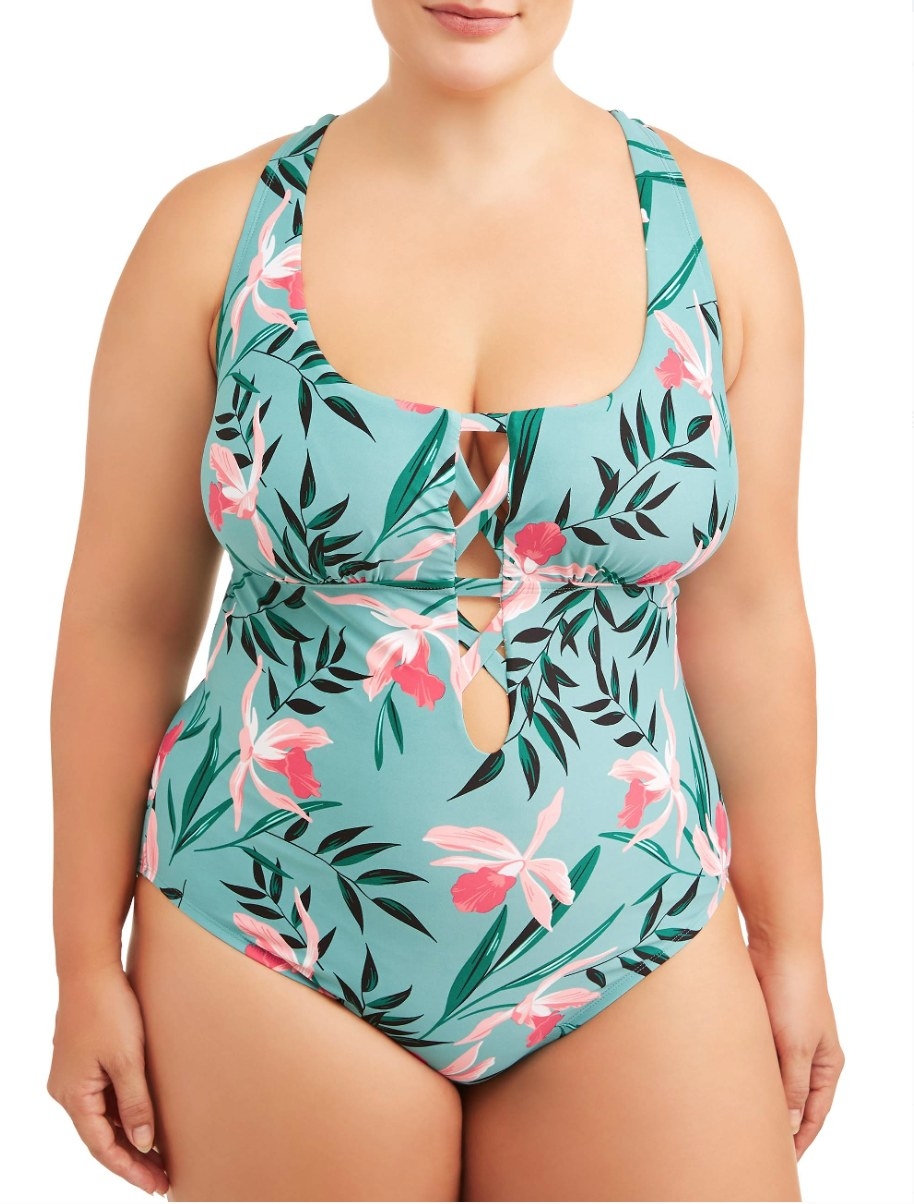 Model in a green one piece with pink floral print 