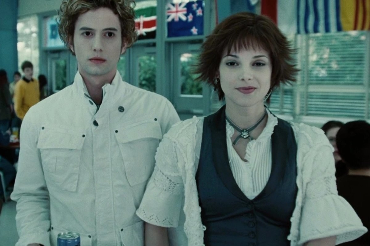 Ashley Greene as Alice smiles coyly while holding hands with boyfriend Jasper (Jackson Rathbone).