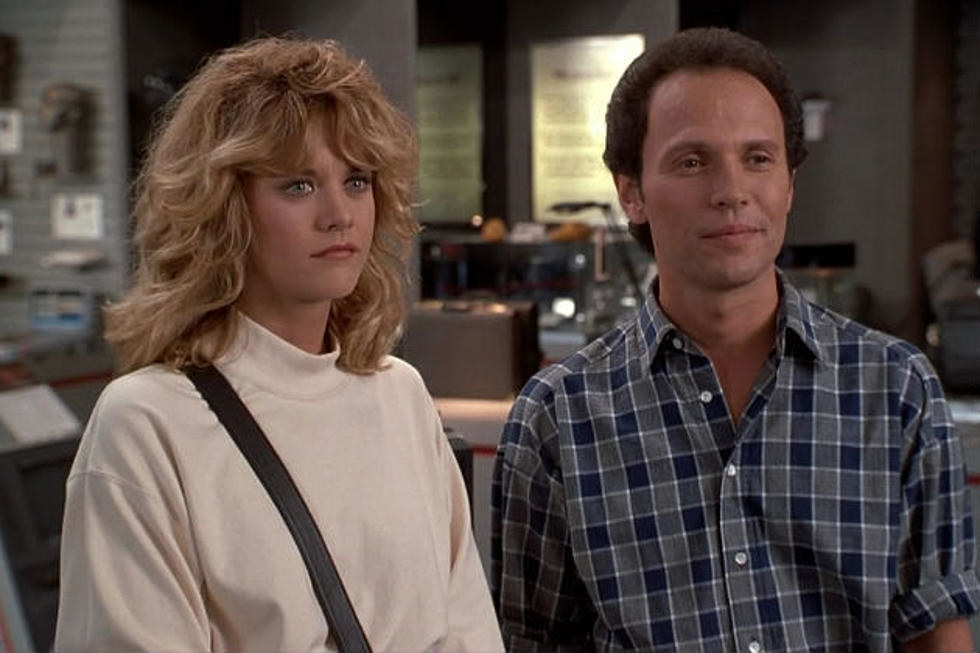 Meg Ryan as Sally and Billy Crystal as Harry stand next to each other in an office.