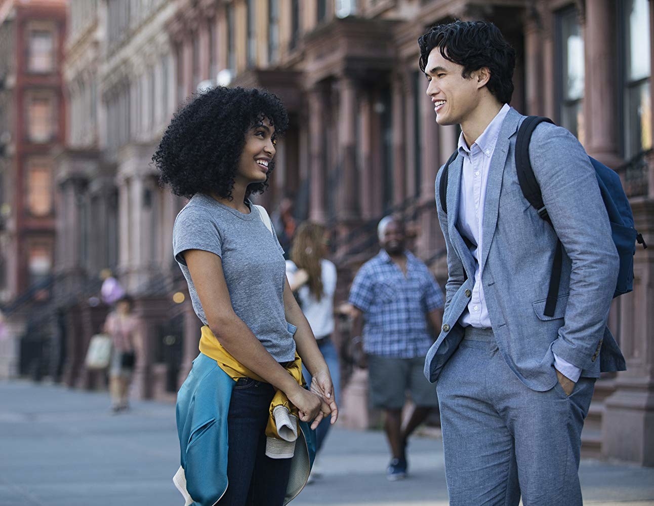 Yara Shahidi as Natasha smiles and talks with Daniel (Charles Melton) in the streets of New York City.