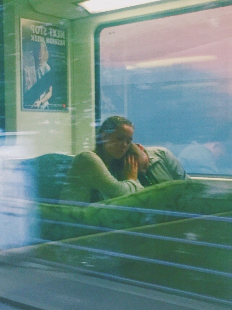 A woman holds a child on a train