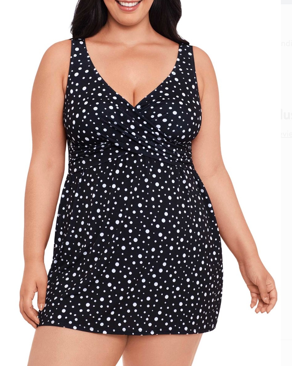 Model in a black swim dress with white polka dots 