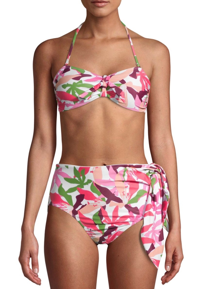 Model in white bikini with pink and green print 