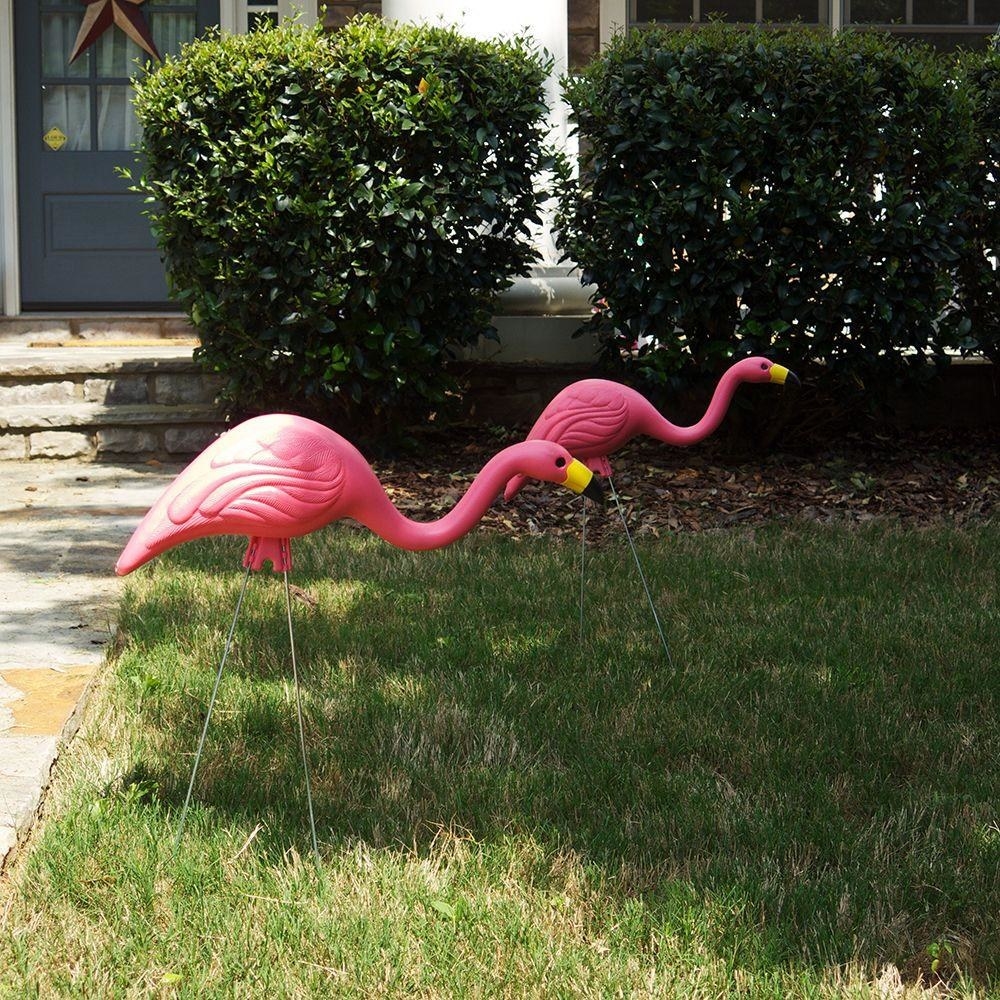 two pink plastic flamingo lawn ornaments