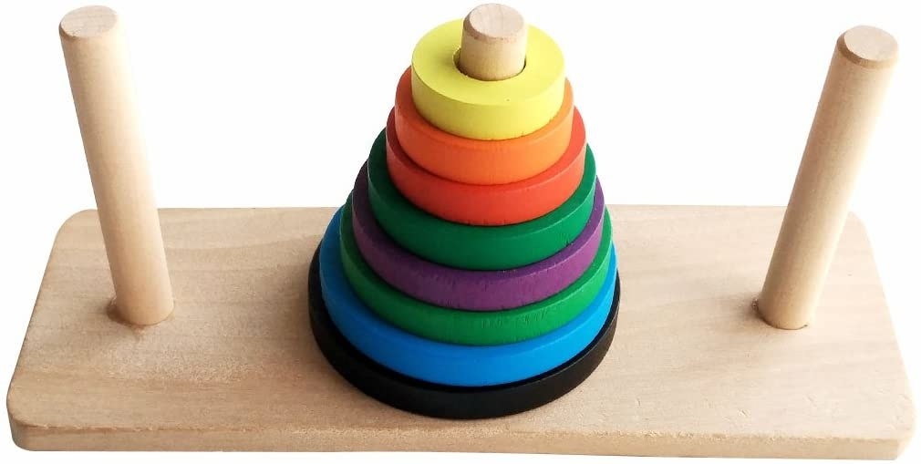 A board with three rods and eight differently sized colored disks stacked on top of each other on the center rod
