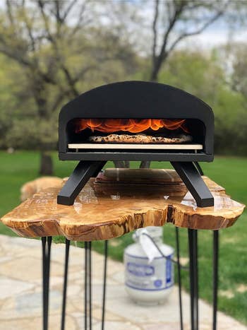 a black curved outdoor pizza oven