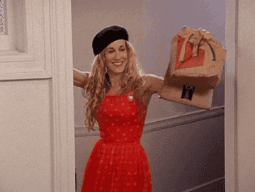 Sarah Jessica Parker wearing a French beret and holding a McDonald&#x27;s to-go bag.