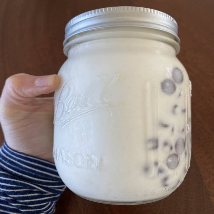 A mason jar filled with cream and chocolate chips.