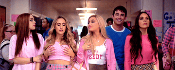 A gif from the music video for Ariana Grande&#x27;s Thank you Next showing Ariana, three girls, and Aaron Samuels walking down a school hallway in pink outfits