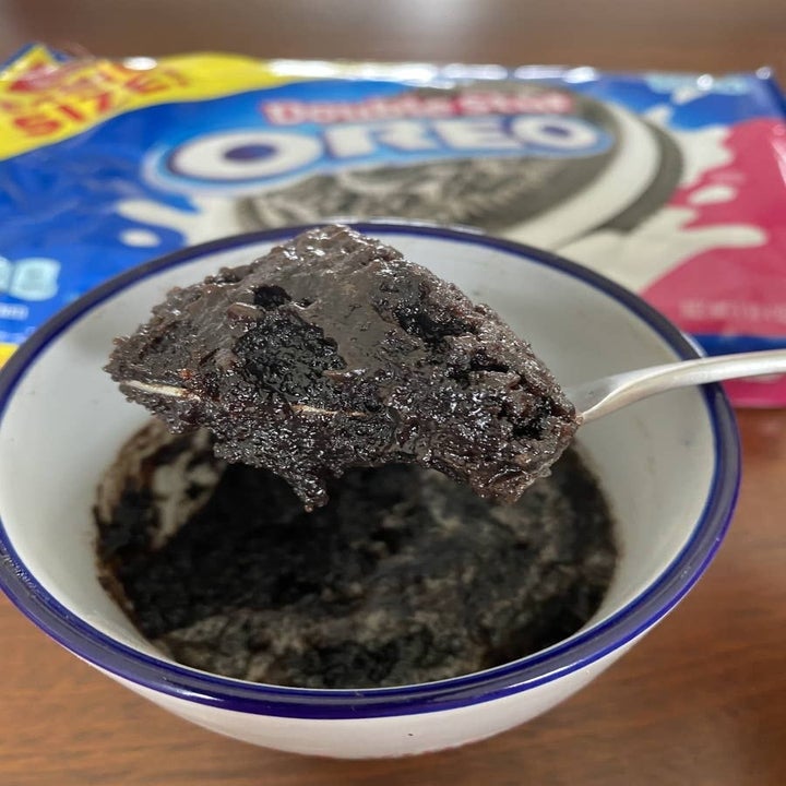A spoonful of Oreo cake in a mug.