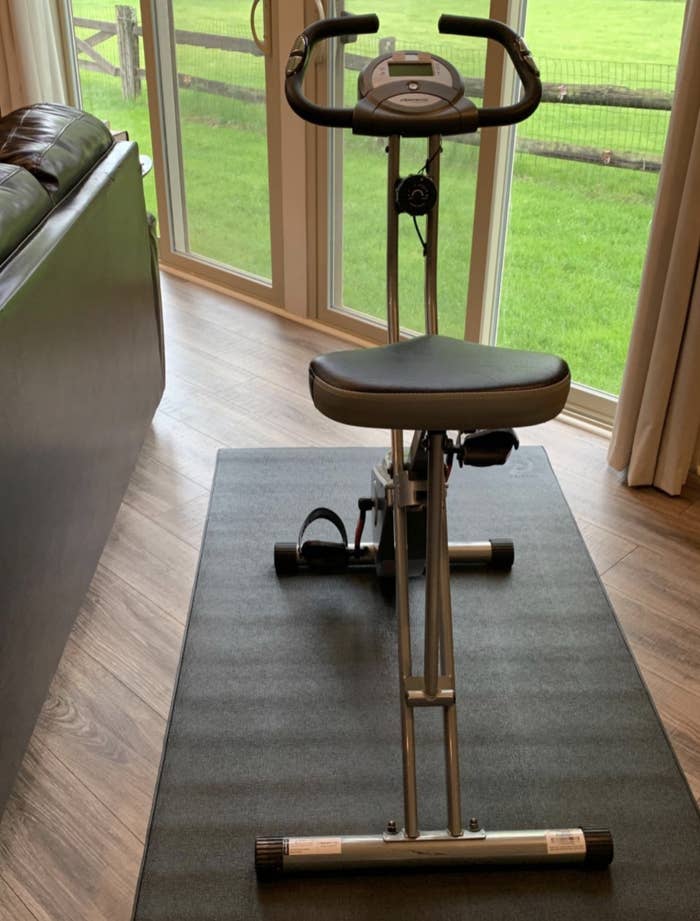 Reviewer image of the bike set up on the mat in the living room