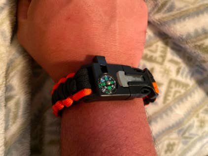 Reviewer wears orange and black paracord on their wrist