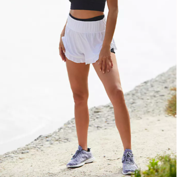 A photo of a person wearing the shorts layered over booty shorts