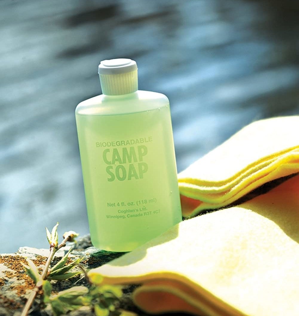 A bottle of camp soap on a rock